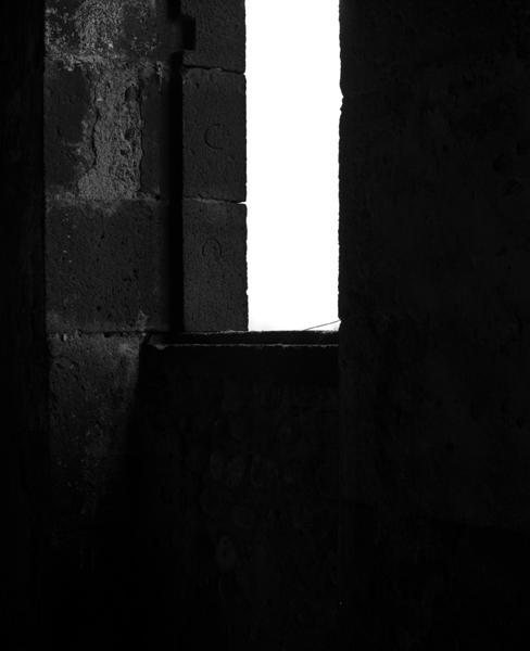 Détail d'un encadrement d'ouverture avec marques de tailleurs de pierre, dans la cage d'escalier de l'ancien corps de logis.
