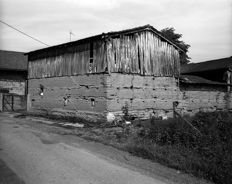 Vue générale d'un séchoir sur étable en pisé et essentage de planches (Les Caires, Limons).