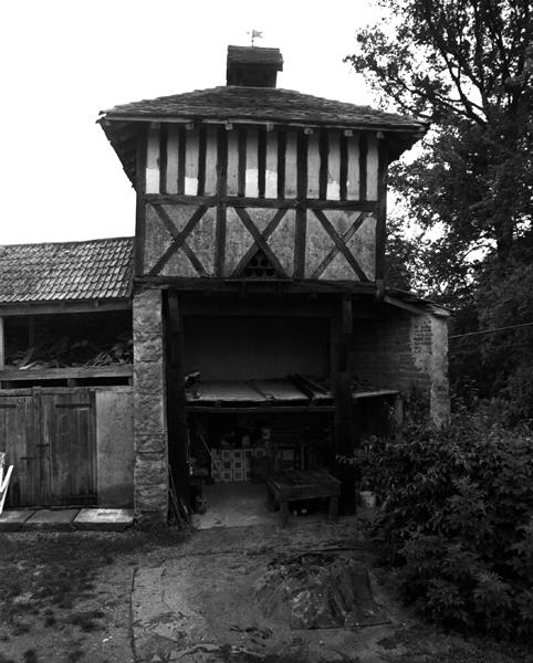 Vue générale d'un pigeonnier à pans de bois sur poteaux, avec base à demi clôturée (Les Maréchaux, Luzillat).