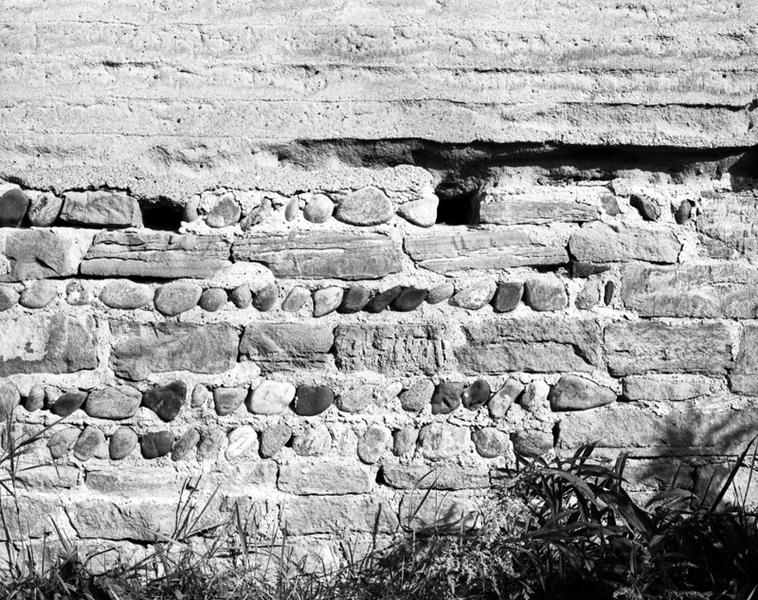 Détail d'un mur en pisé sur solin de moellons et de galets (village de Demolles).