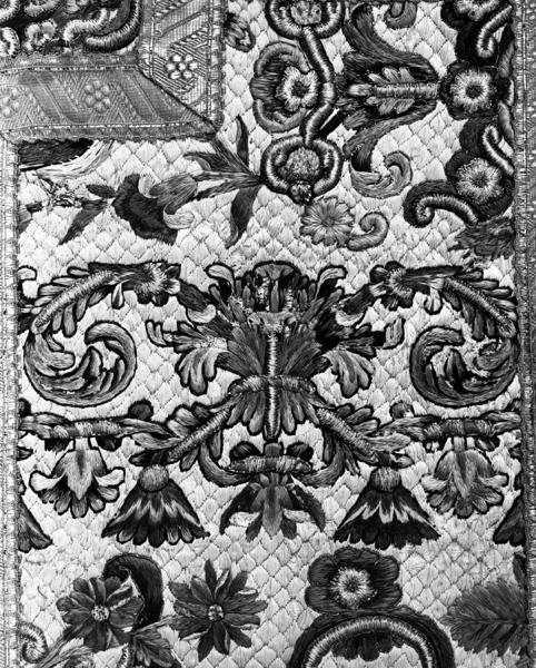 Chasuble, dos, fond, à droite du montant de la croix, détail : fragment de frise à feuilles d'acanthe au-dessous de la traverse.