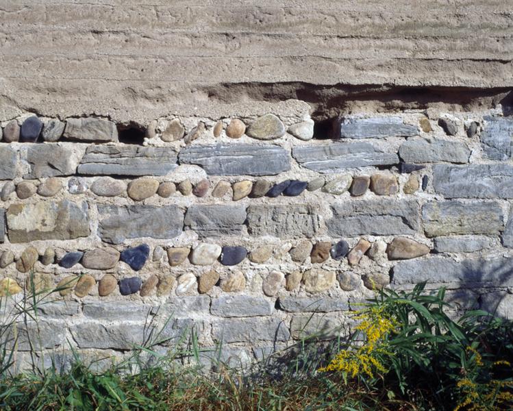 Détail d'un mur en pisé sur solin de moellons et de galets (village de Demolles).