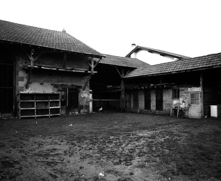 Vue générale de la remise et du séchoir sur porcherie depuis la cour