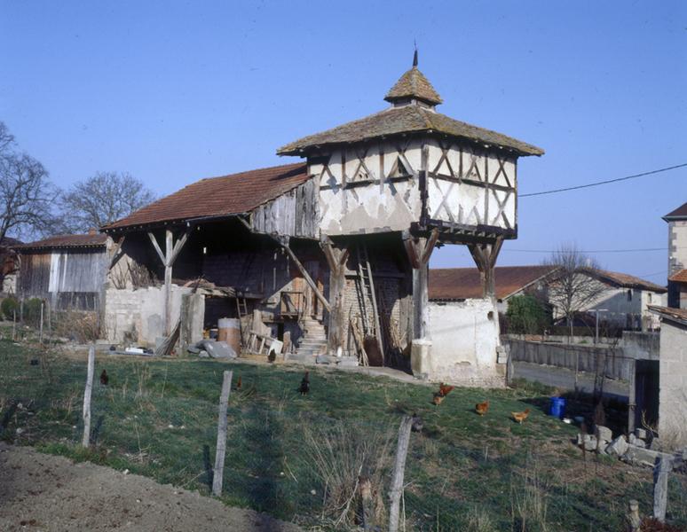 Vue générale d'un pigeonnier à pans de bois sur poteaux, avec base à demi clôturée (Vensat, Maringues).
