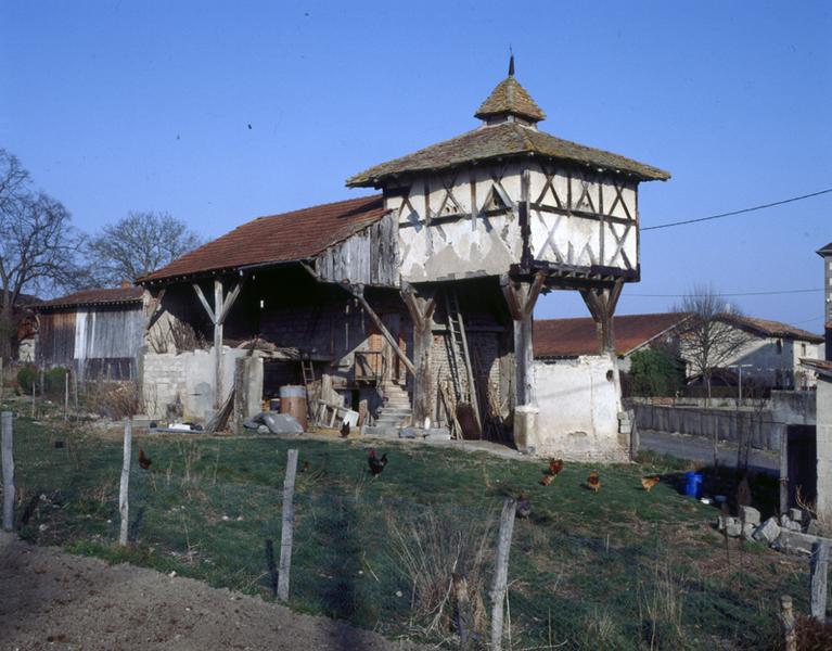 Vue générale d'un pigeonnier à pans de bois sur poteaux, avec base à demi clôturée (Vensat, Maringues).