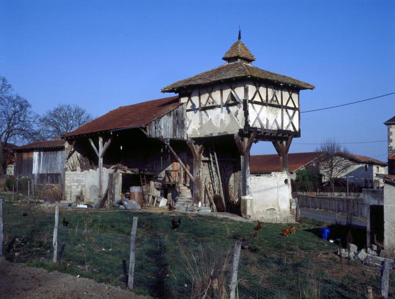 Vue générale d'un pigeonnier à pans de bois sur poteaux, avec base à demi clôturée (Vensat, Maringues).