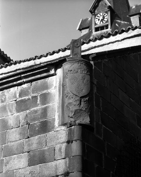 Détail d'un socle en remploi avec blason aux armes martelées, à l'angle de la chapelle nord-est.