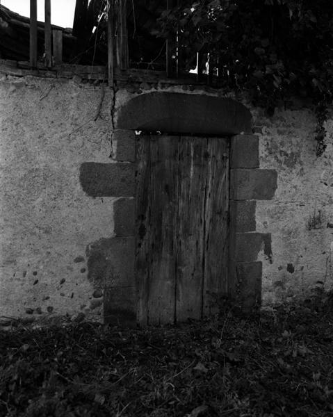 Détail d'une porte à linteau monolithe délardé, en andésite (Maringues, ville).