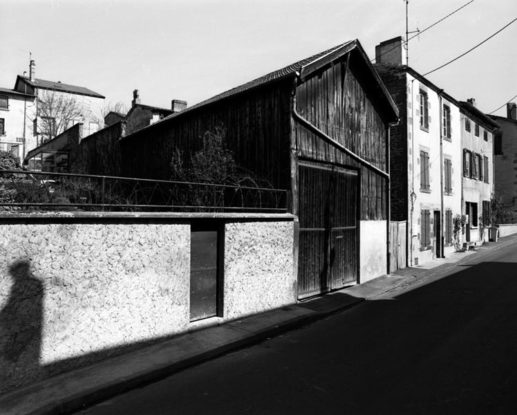 Vue générale d'une dépendance urbaine, avec essentage de planches (Maringues, ville).