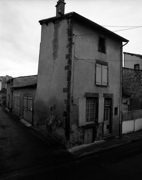 Vue générale d'une maison à façade étroite et entrée de cave ouvrant sur l'extérieur (Maringues, ville).