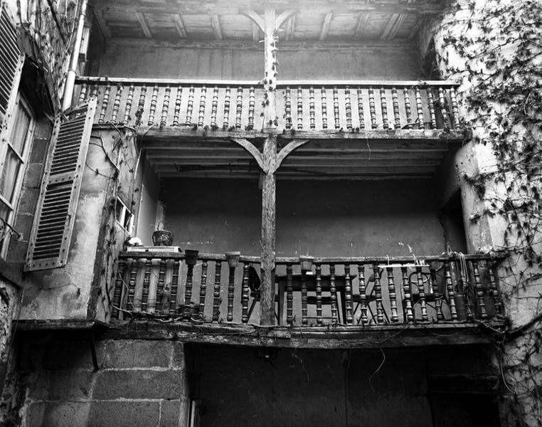 Détail d'une galerie sur cour en charpente, ouvrant, d'un côté, sur une tour d'escalier (Maringues, ville).