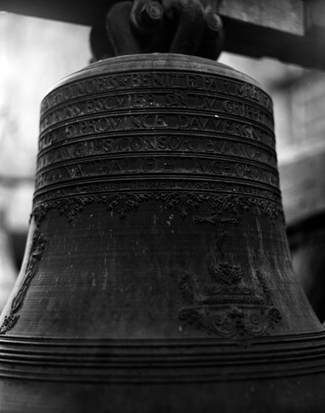 'Cloche 2, face postérieure, détail : sur le vase supérieur, les six lignes de l'inscription et la frise ; sur la faussure, Calvaire, à droite (à gauche, la Vierge à l'Enfant de la face latérale).'