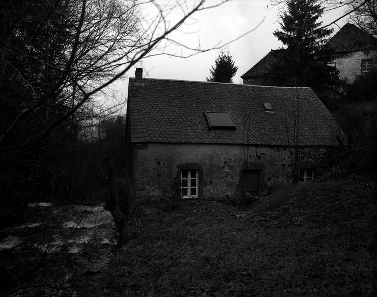 Vue de la façade principale. En haut, les toits appartiennent au nouveau logis et au four à pain.