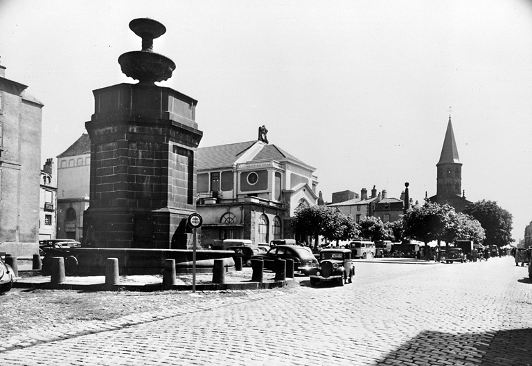 Vue générale de la place, du château d'eau, du marché et du clocher de l'église Saint-Amable