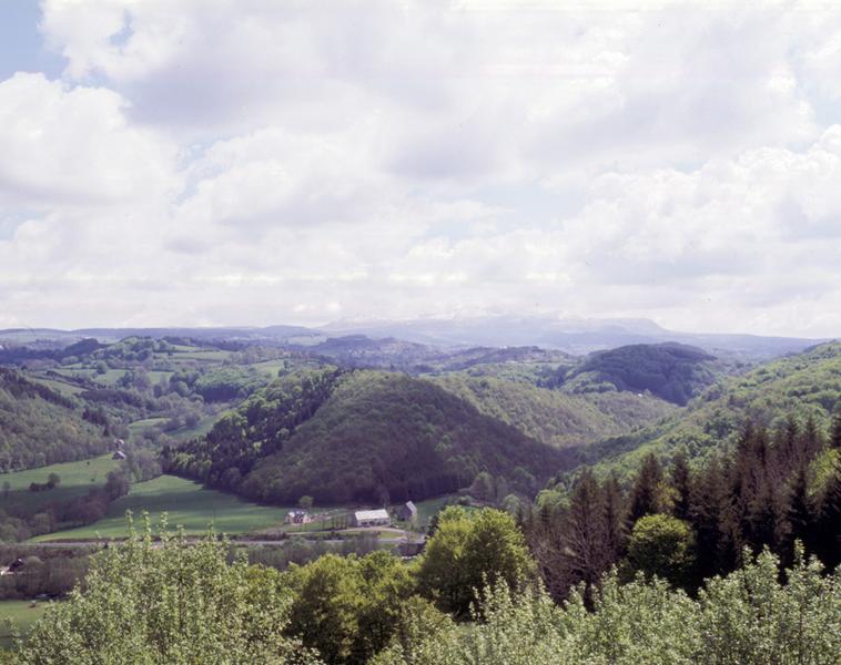 Vue générale de la vallée de la Burande depuis la route de Bagnols. La commanderie s'élevait au débouché du vallon de gauche, le long de l'ancienne route royale de Clermont à Aurillac.