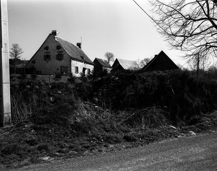 Vue générale du logis et des dépendances agricoles, avec une ancienne grange étable ruinée au premier plan.