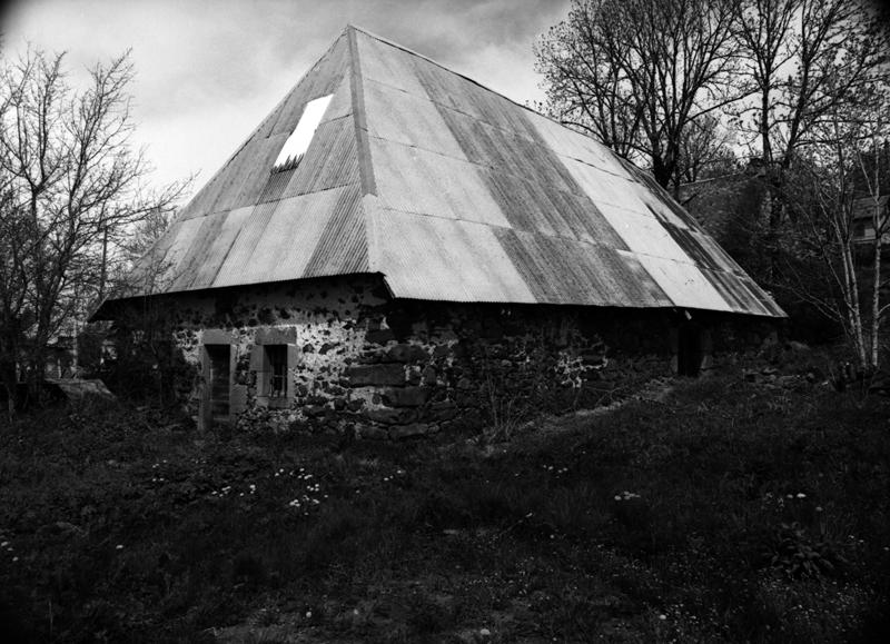 Vue générale de trois-quarts de la ferme en maison bloc. Le logis s'ouvre sous la croupe.