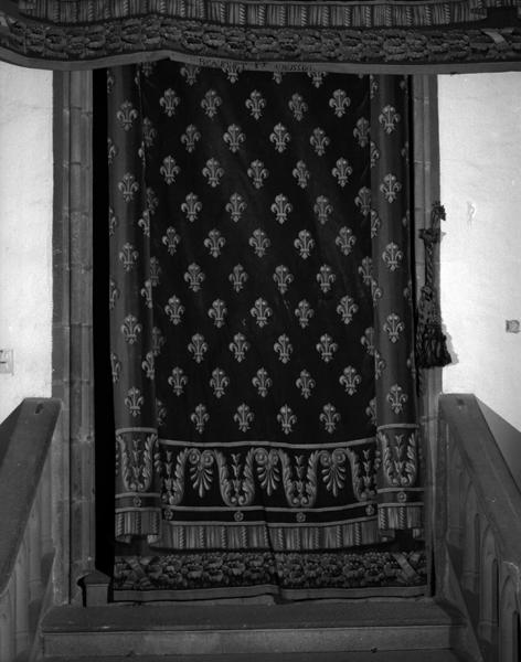 Portière masquant actuellement l'entrée principale de la Sainte-Chapelle. A droite : passementerie et bouton de suspension contemporains de la chancellerie. - © Région Auvergne - Inventaire général du Patrimoine culturel, ADAGP