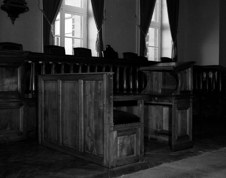 Vue de trois-quarts de deux meubles combinés : une table à écrire avec pupitre de table et une banquette dont une place à accotoirs, en face du pupitre, fait office de fauteuil.
