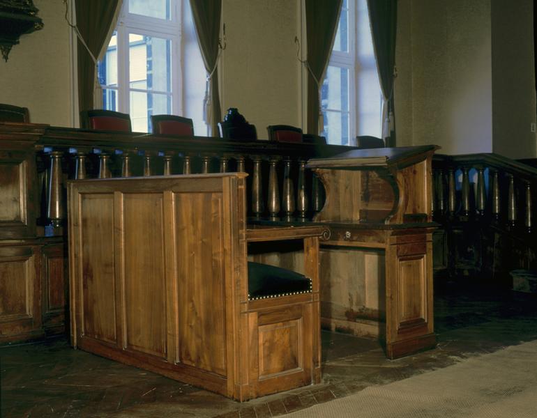 Vue de trois-quarts de deux meubles combinés : une table à écrire avec pupitre de table et une banquette dont une place à accotoirs, en face du pupitre, fait office de fauteuil.