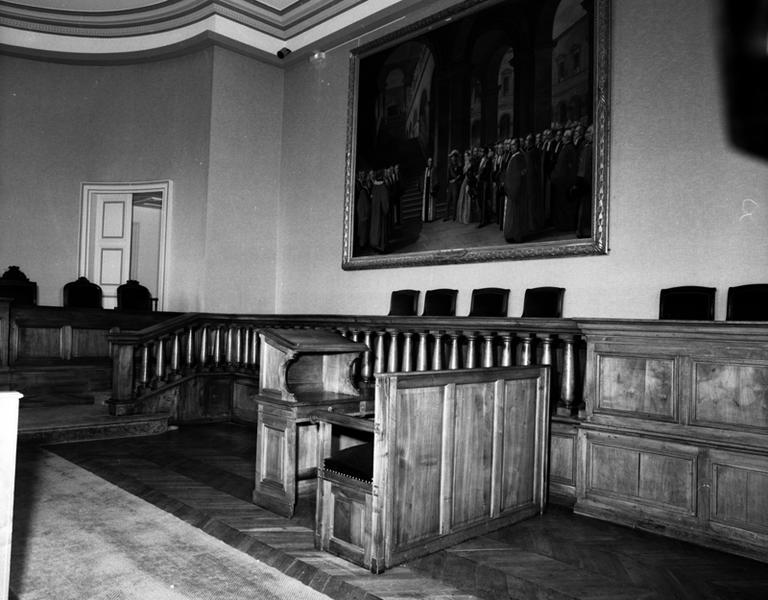 Vue partielle de la salle d'audience avec, en second plan, l'estrade, le garde-corps, et deux tables à écrire (en premier plan, les deux meubles combinés).