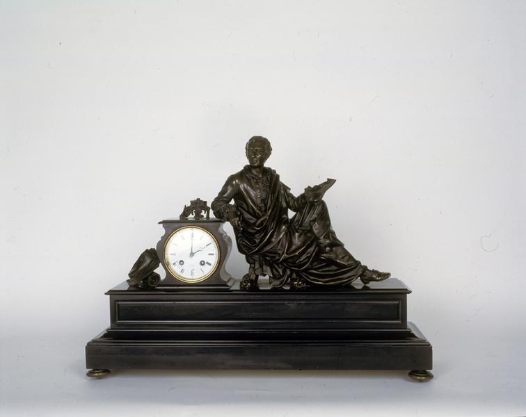 Horloge décorée de la figure de Montesquieu écrivant l'Esprit des lois. La pose un peu artificielle indiquerait que la statuette a été spécialement conçue pour orner ce type d'objet.