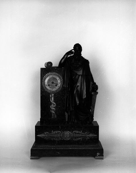 Vue de face de l'horloge faisant partie d'une garniture de cheminée, avec la figure de Lycurgue d'après la légende du dessin de l'architecte Mallay.