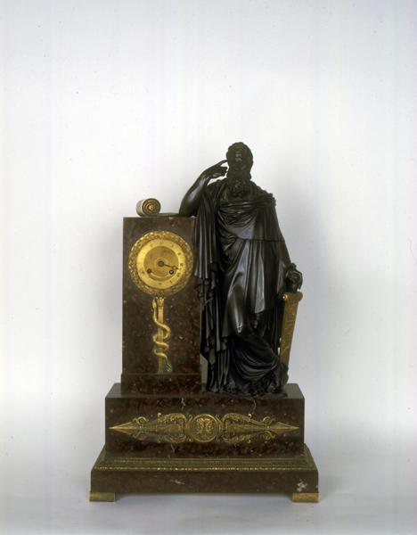 Vue de face de l'horloge faisant partie d'une garniture de cheminée, avec la figure de Lycurgue d'après la légende du dessin de l'architecte Mallay