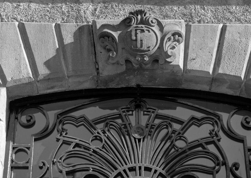 Vue de la clef d'arc de la porte d'entrée principale, sculptée au monogramme de l'un des propriétaires, M. Sennegy.