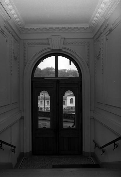 Vue de la porte d'entrée depuis l'escalier du hall
