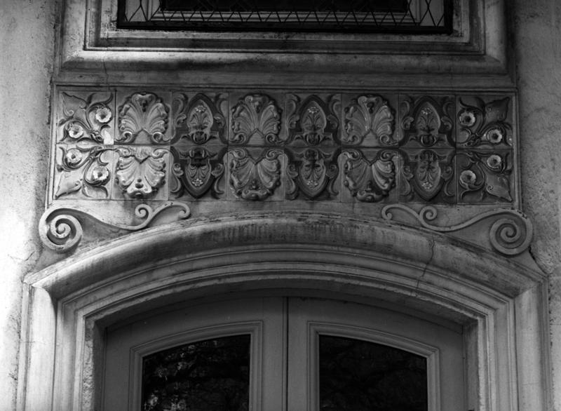 Détail du décor en céramique au-dessus de l'une des portes ouvrant sous le portique.