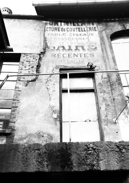 Vestiges d'une enseigne publicitaire peinte sur la façade