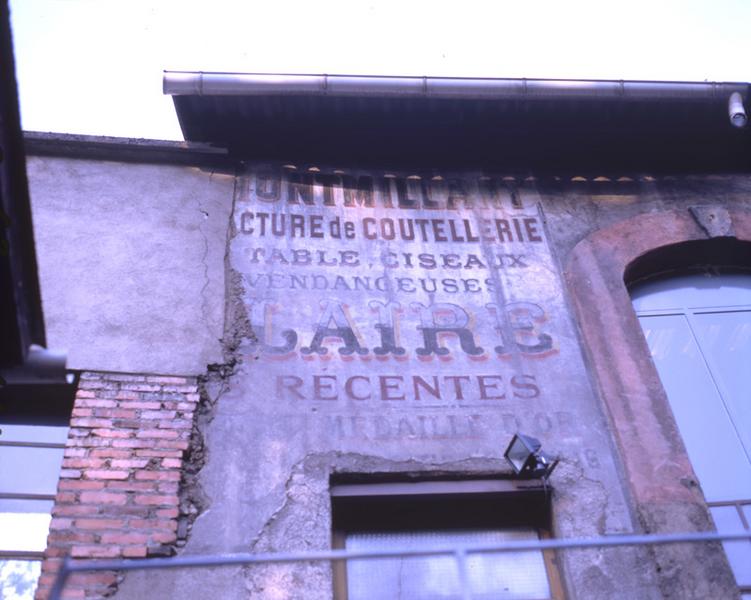 Vestiges d'une enseigne publicitaire peinte sur la façade