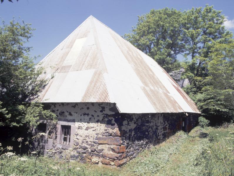 Vue générale de trois-quarts de la ferme en maison bloc. Le logis s'ouvre sous la croupe.