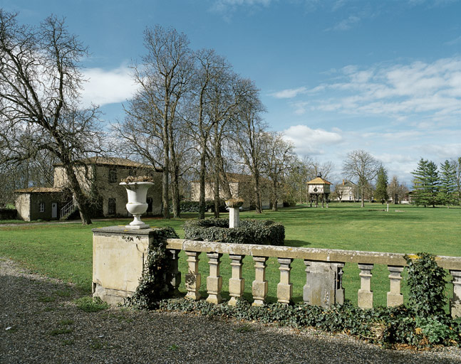 L'étable, la grange et le pigeonnier sur poteaux vus depuis l'est, au premier plan, la balustrade devant le corps de logis.