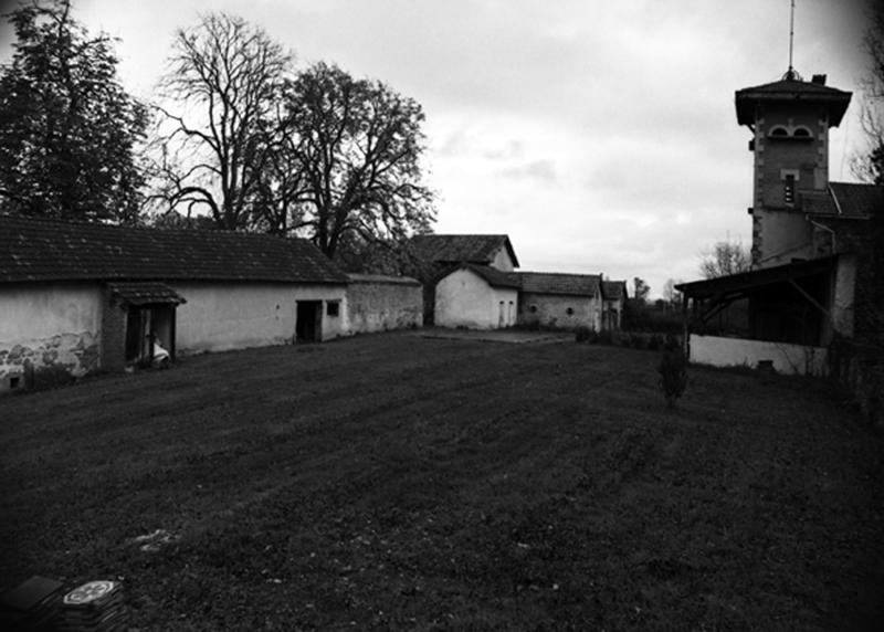 Vue de la cour de ferme avec à gauche les resserres et les étables