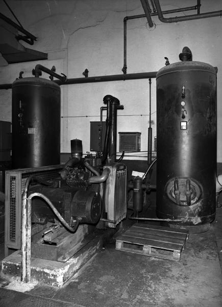 Atelier de production d'air comprimé pour les marteaux-pilons : détail d'un compresseur et de deux cuves.