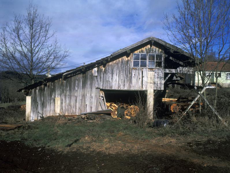 Vue latérale de la scierie au premier plan, maison au second plan