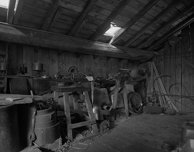 A l'étage : étau large pour écraser les dents de la lame de la scie à ruban et machine à affûter les lames de rabotteuse.