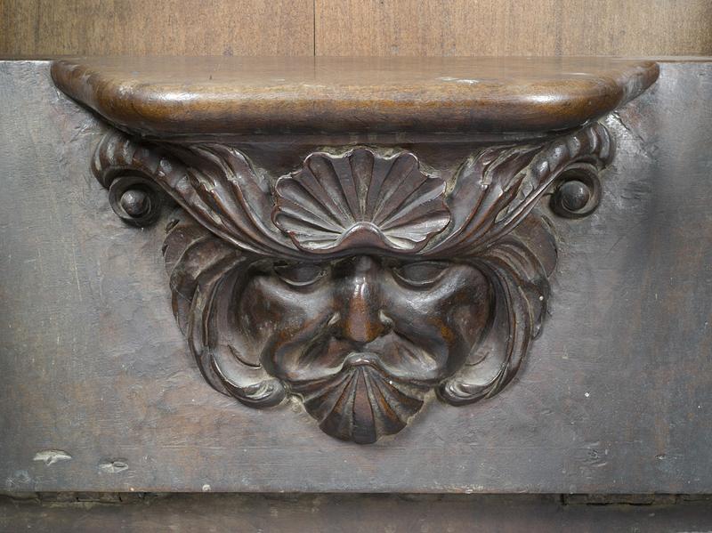 Vue de détail d'une miséricorde : mascaron aux coquilles saint Jacques