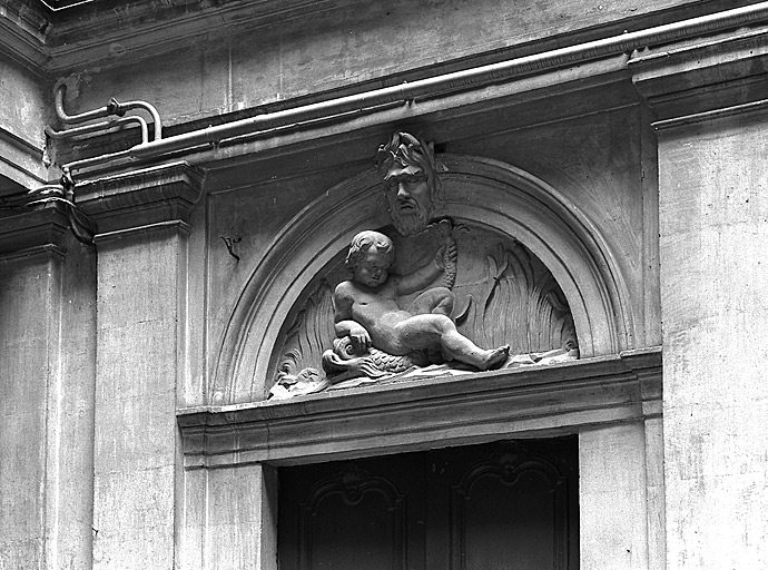 Tympan et clef sculptés de la porte du rez-de-chaussée, façade Est sur cour. Enfant sur un dauphin et Neptune.