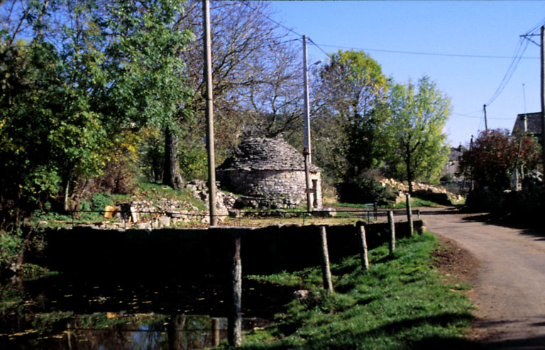 Vue d'ensemble prise de l'ouest du puits et de l'abreuvoir en premier plan.