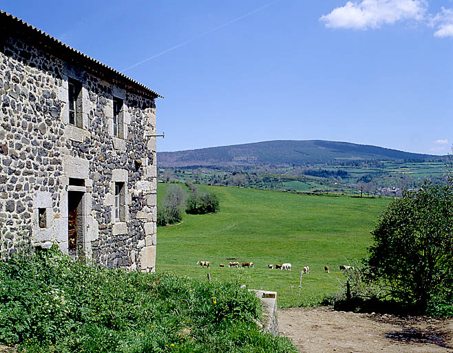 Vue du paysage de la Margeride, prise vers l'est ; sur la gauche, le logis d'une ferme de Julianges