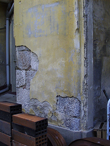 Détail du parement sous l'enduit de refaçadage du portique extérieur de l'église côté cloître.