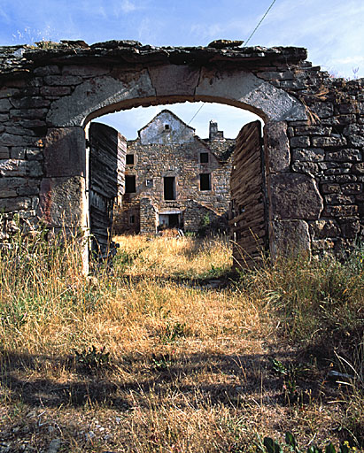 Vue de la ferme prise du sud avec la porte charretière en premier plan.