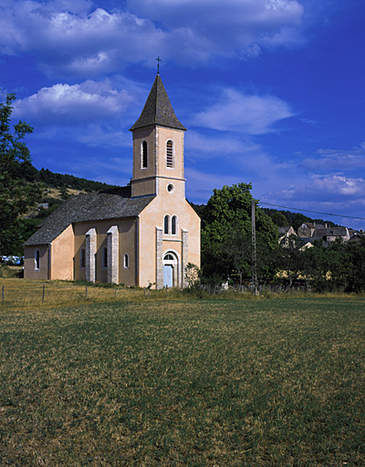 Vue d'ensemble de l'église et prise de l'ouest avec le village en arrière plan.