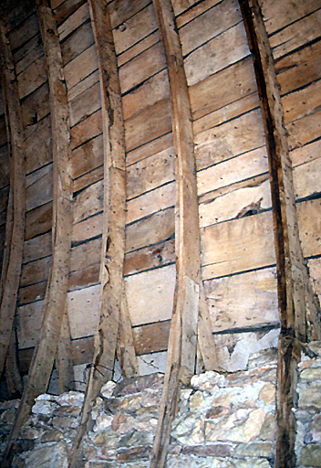 Détail de la charpente du toit en carène de la grange.