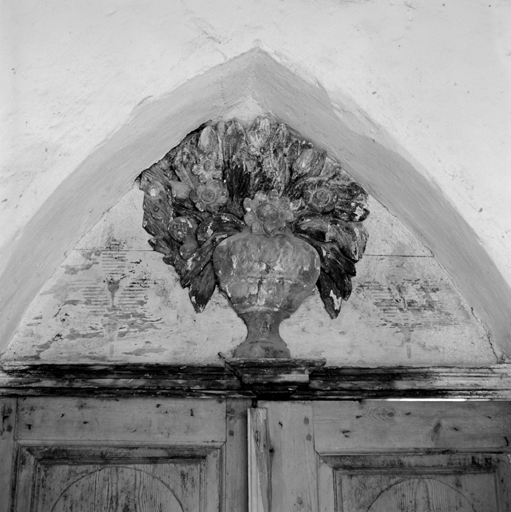 Ancienne porte de la chapelle, dans le mur nord de la première travée. Face sud. Pot à fleur.