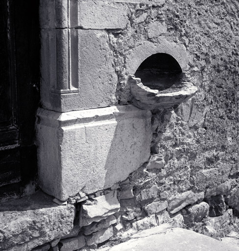 Façade sud. Porte d'entrée. Détail de la modénature du piédroit et bénitier.