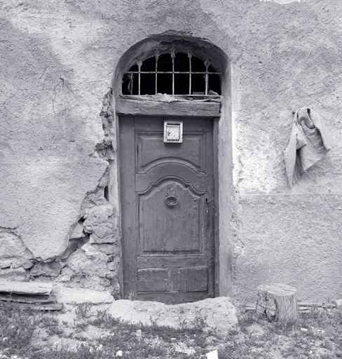 Porte d'entrée de la "court", initialement à deux battants. Menuiserie à panneaux.